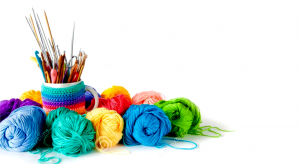 Colorful skeins of yarn with knitting needles and crochet hooks